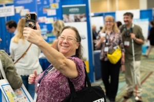 ATIA conference attendee having fun while taking a selfie in the exhibit hall.