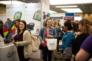 Attendees and exhibitors engage together in the exhibit hall. 