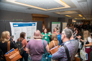 Jam-packed hallway at ATIA 2024 as speakers share their findings during their poster session.