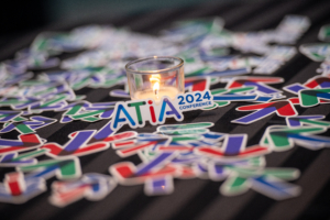 ATIA Celebration decorations - stickers of the ATIA 2024 logo and arrows. Placed with a lit candle in the center of the table.