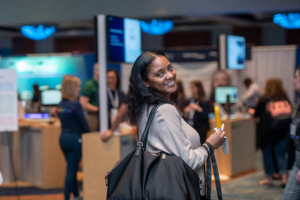 An ATIA attendee enjoys her afternoon refreshment while checking out the latest AT products in the Exhibit Hall.