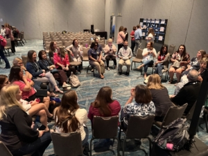 ATIA 2024 attendees sit in a circle and discuss things they've learned so far at the conference.