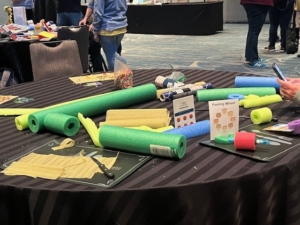 Maker Day DIY supplies sitting on a table, including swimming noodles, scissors, paper, and more.