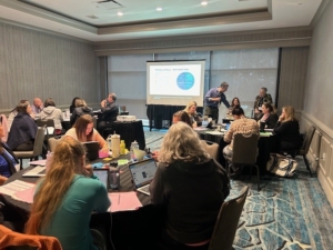 Pre-Conference attendees sitting at round tables while learning at the seminar.