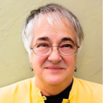 Picture of Gayl Bowser wearing glasses and a yellow blouse with a black shirt underneath.