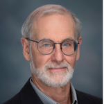 Picture of Jon Sandford wearing a black sport coat over a gray dress shirt.