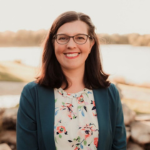 Picture of Laura Rice wearing a dark green blazer over a blouse with flowers.