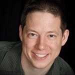 Picture of Mike Cole wearing a button up shirt with green and black stripes.