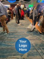 ATIA conference exhibit hall with sample sponsor sticker on the floor. The text reads, 