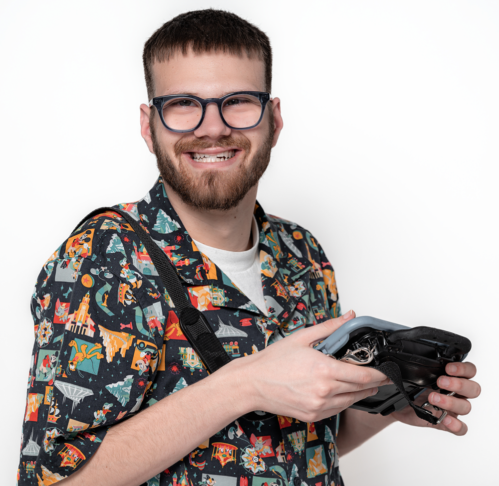 Picture of Mateo Moreno. He is holding an AAC device and wearing a brightly colored shirt.