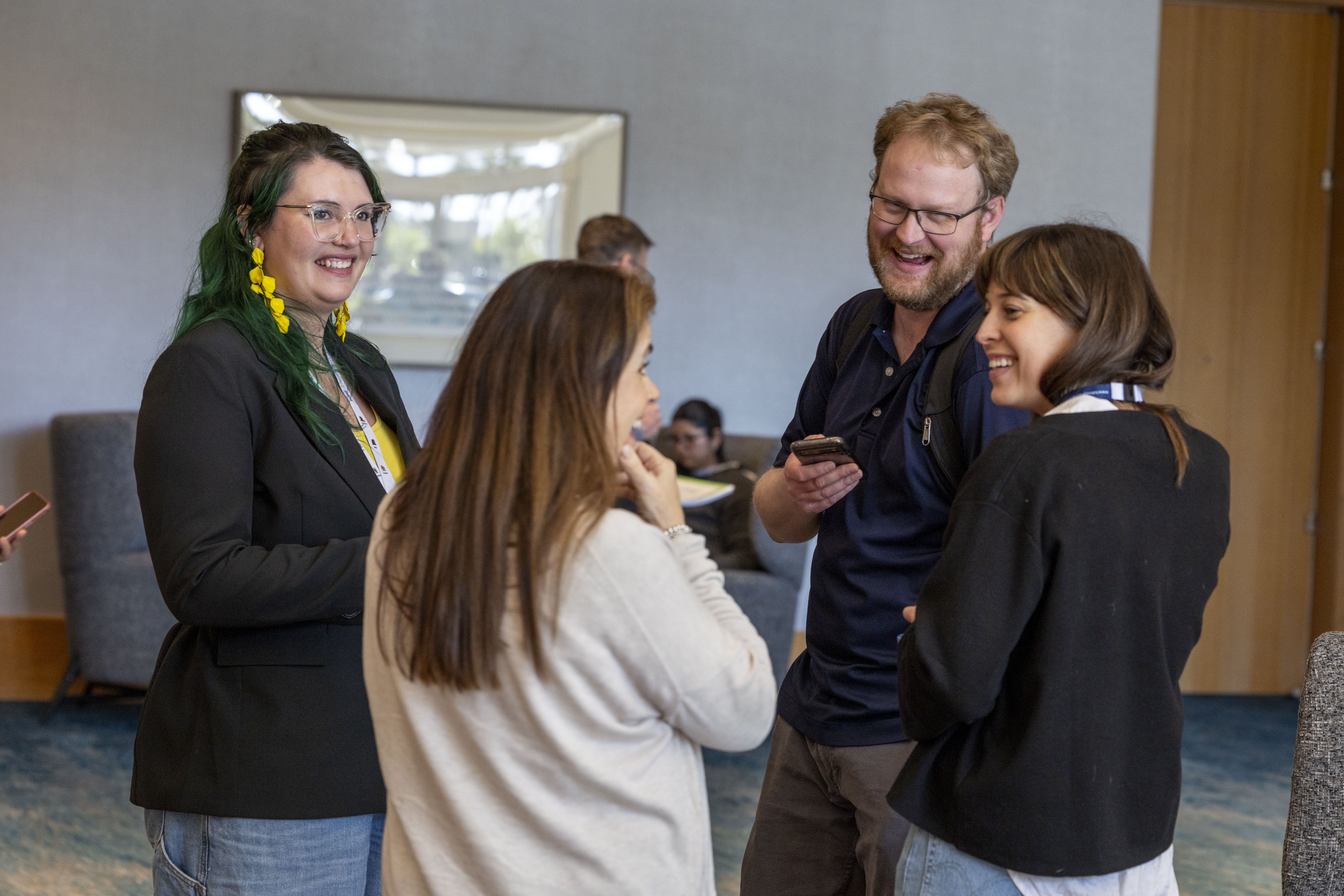 Group of four people laughing at an ATIA conference.